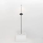The black Pina Pro Floor Stand from Zafferano is standing in a white planter in a studio.