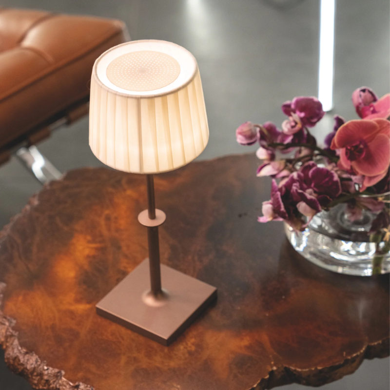 The bronze Polinda Classic from Zafferano on a wood table in a living room.