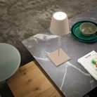 The sand Poldina Pro L Desk Lamp from Zafferano in a living space.
