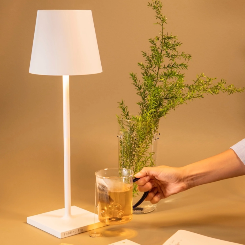 The white Poldina Pro L Desk Lamp from Zafferano in a living area.