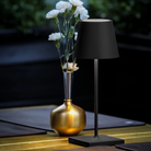 The black Poldina Pro Mini from Zafferano in an outdoor living space.