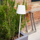 The white Poldina Pro Peg Magnetic from Zafferano outdoors in a cafe garden.