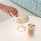 The anodized gold Sister Light Mini Wi-Fi Table Lamp from Zafferano in a family area.