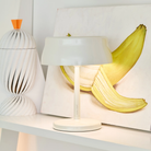 The white Sister Light Mini Wi-Fi Table Lamp from Zafferano in a lounge.