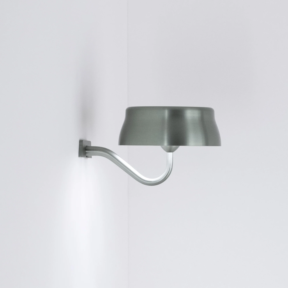The anodized green Sister Light Wi-Fi Wall Lamp from Zafferano in a studio.