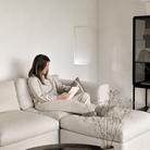 The Mellow End Seater from Ethnicraft in the family room with a woman reading a book.