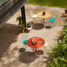 The Eames Dining Table from Herman Miller, designed by Herman Miller x Hay in a garden space.