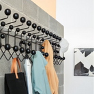 The Eames Hang-It-All from Herman Miller in a linear row, showing the multiple uses of the rack.