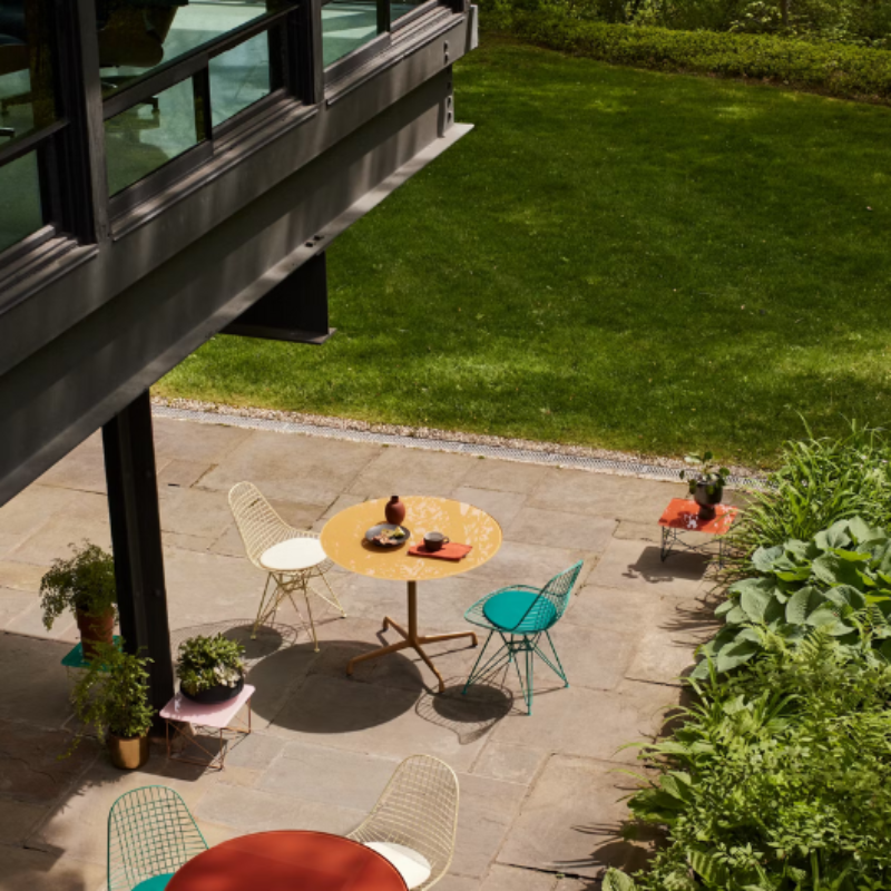 The Eames Wire Chair from Herman Miller, designed by Herman Miller x HAY in a courtyard. all-groups