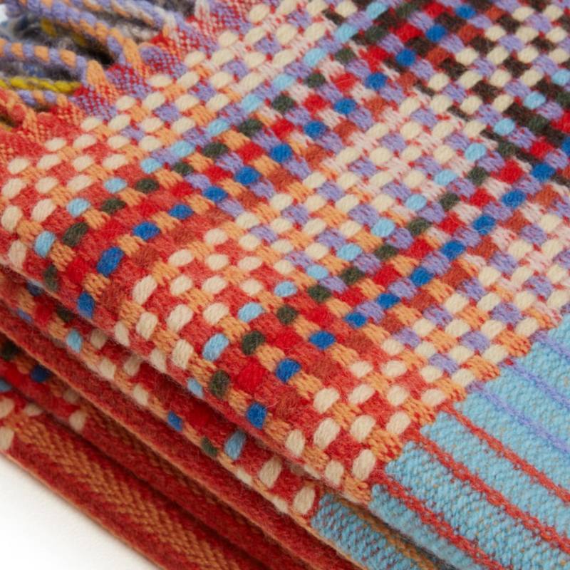 The Beatrix Throw by Wallace & Sewell is made of woven merino lambswool. The Pinstripe collection combines bold-colored blocks with fine, detailed vertical stripes. This double-sided design also has a contrasting pixelated border and is a stunning room addition