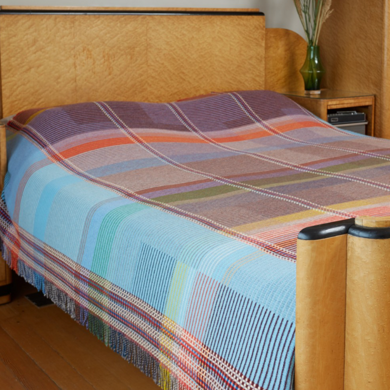 The Beatrix Throw by Wallace & Sewell is made of woven merino lambswool. The Pinstripe collection combines bold-colored blocks with fine, detailed vertical stripes. This double-sided design also has a contrasting pixelated border and is a stunning room addition