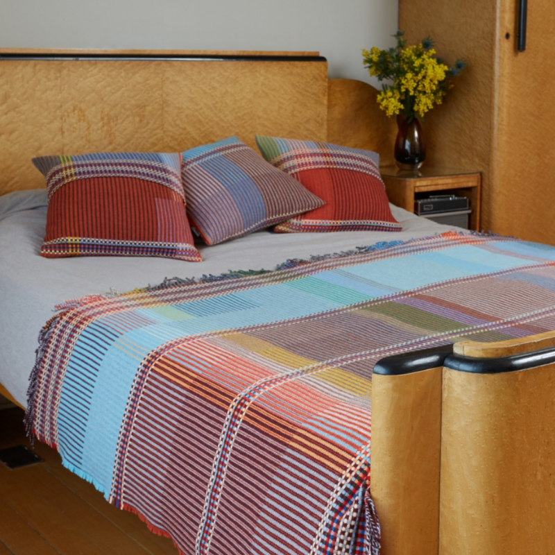 The Beatrix Throw by Wallace & Sewell is made of woven merino lambswool. The Pinstripe collection combines bold-colored blocks with fine, detailed vertical stripes. This double-sided design also has a contrasting pixelated border and is a stunning room addition