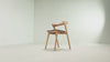 The Bok Upholstered Dining Chair from Ethnicraft in oak with dark brown fabric in a studio video.
