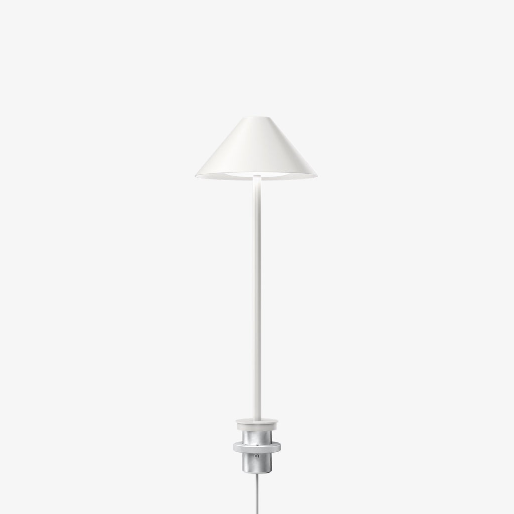 The Keglen table lamp’s distinctive conical shade has a built-in curved diffuser. This ensures an attractive and glare-free downwardly directed light. The stem morphs into the diffuser shade, folding inward and creating a beautiful organic geometry. A gentle light is also emitted upward through a discreet uniform opening in the top of the shade to create a perfect ambiance. Designed by Jakob Lange.