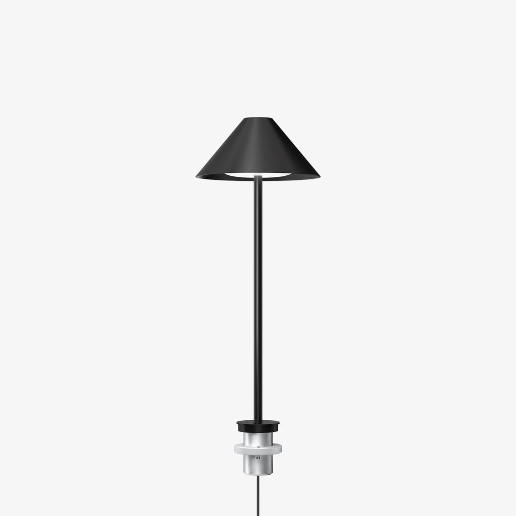 The Keglen table lamp’s distinctive conical shade has a built-in curved diffuser. This ensures an attractive and glare-free downwardly directed light. The stem morphs into the diffuser shade, folding inward and creating a beautiful organic geometry. A gentle light is also emitted upward through a discreet uniform opening in the top of the shade to create a perfect ambiance. Designed by Jakob Lange.