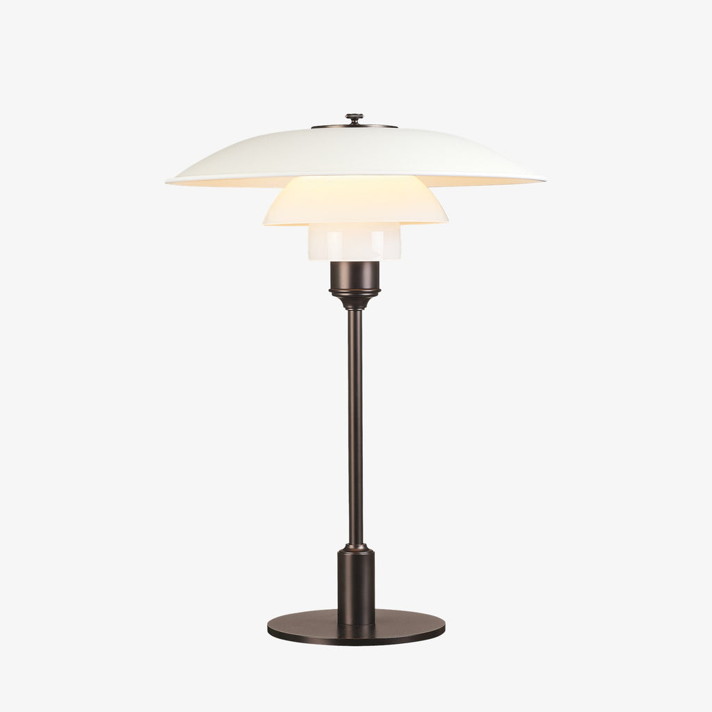 The PH 3½-2½ table lamp is designed based on the principle of a reflective three-shade system, which directs the majority of the light downwards. The shades are made of mouth-blown opal three-layer glass, which is glossy on top and sandblasted matt on the underside, giving a soft and diffuse light distribution. Designed by Poul Henningsen.