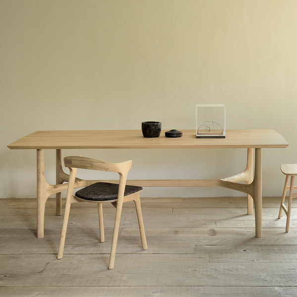 The Nexus Dining Table by Ethnicraft is brought to life by creating flow and movement. There is a certain subtle transition going from shape to shape within the design of the table. A single line that was almost instinctively sketched on paper in the early stages of the design process. All elements are seamlessly merged together bringing warmth to any dining room. 
