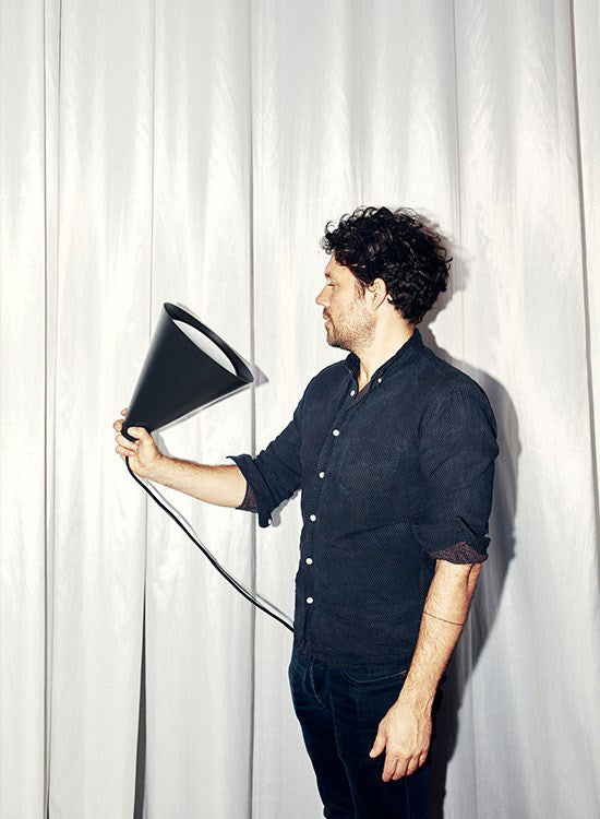 Designer Jakob Lange of BIG Ideas holds the Keglen Pendant light in Black