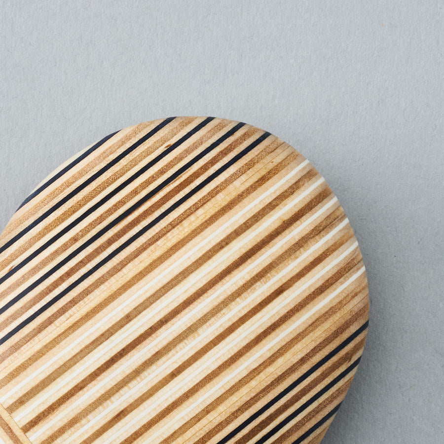 Pebble-like paperweights made by joining beautiful plywood pieces in a patchwork style. Designed by Drill Design.