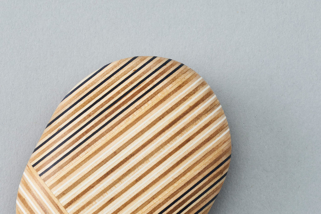 Pebble-like paperweights made by joining beautiful plywood pieces in a patchwork style. Designed by Drill Design.