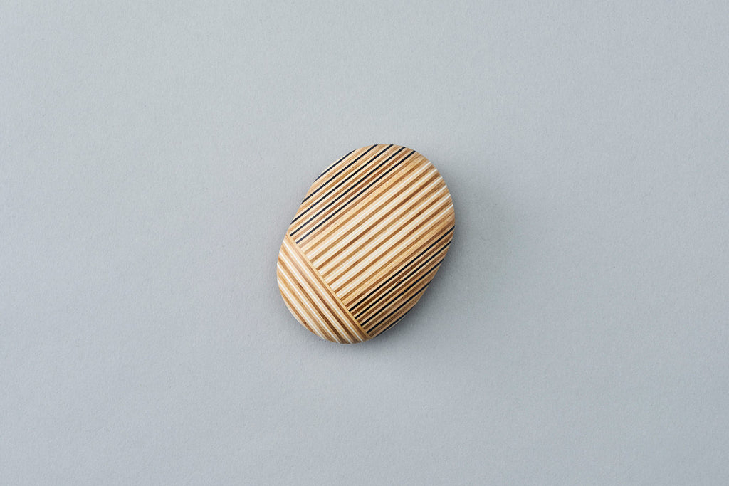Pebble-like paperweights made by joining beautiful plywood pieces in a patchwork style. Designed by Drill Design.