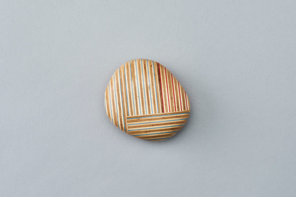 Pebble-like paperweights made by joining beautiful plywood pieces in a patchwork style. Designed by Drill Design.