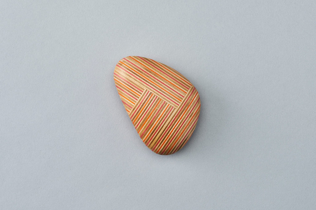 Pebble-like paperweights made by joining beautiful plywood pieces in a patchwork style. Designed by Drill Design.