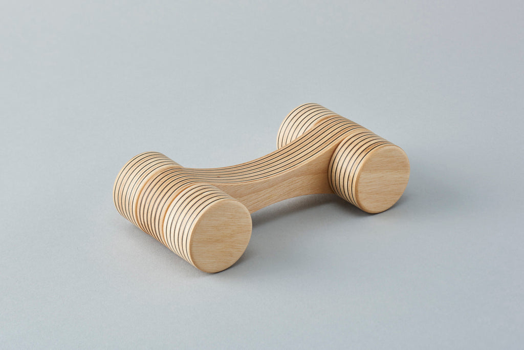 A car-shaped object with a smoothly abstracted design achieved by slimming down the form to the max. Offers the beauty of the plywood’s continuous striped pattern. Designed by Drill Design.