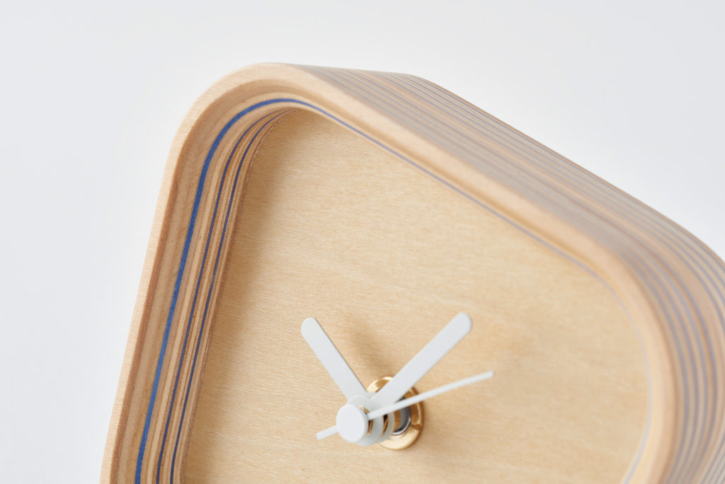 A clock that can be placed either vertically or horizontally owing to a form born of the hours and angles when the hands overlap. Its sense of presence changes dramatically depending on the way you place it. Designed by Fullswing. 