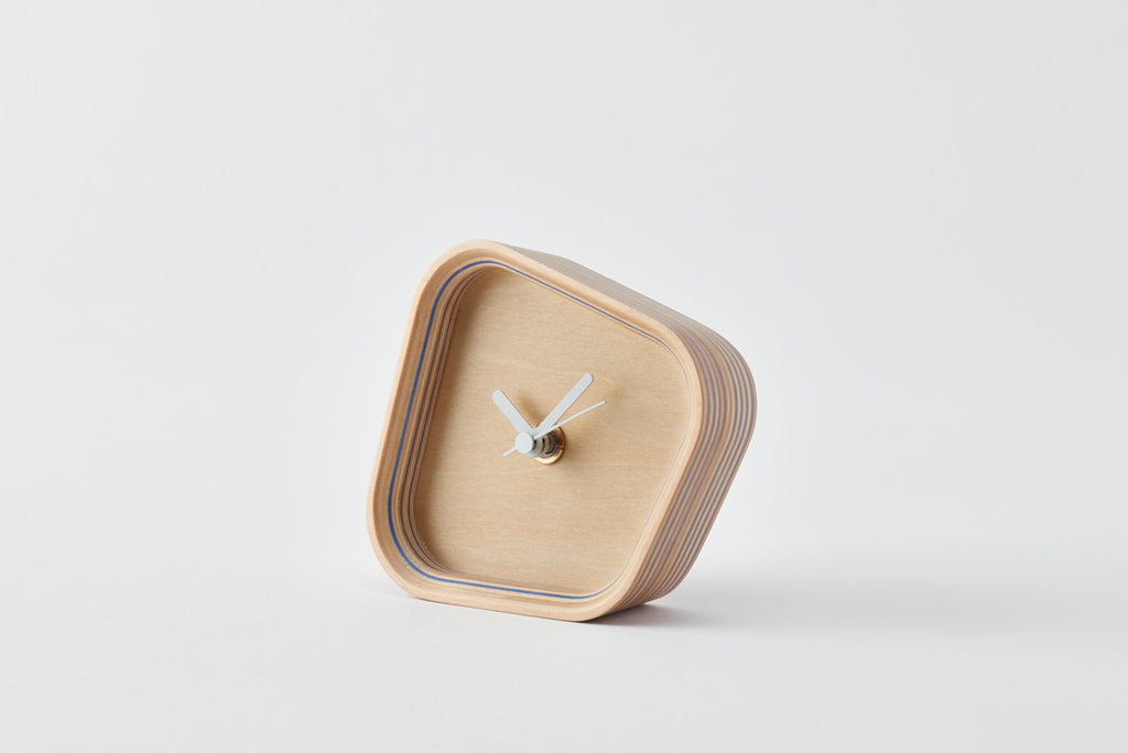 A clock that can be placed either vertically or horizontally owing to a form born of the hours and angles when the hands overlap. Its sense of presence changes dramatically depending on the way you place it. Designed by Fullswing. 