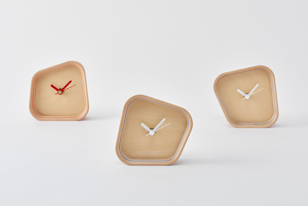A clock that can be placed either vertically or horizontally owing to a form born of the hours and angles when the hands overlap. Its sense of presence changes dramatically depending on the way you place it. Designed by Fullswing. 