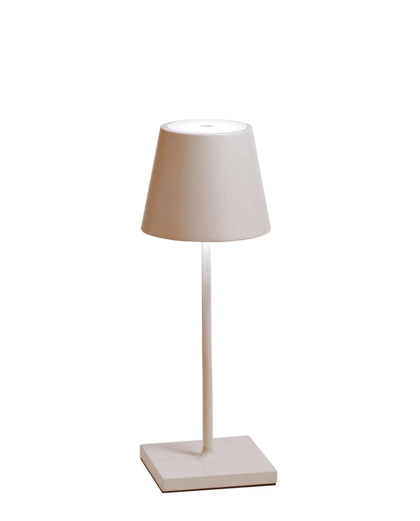 The Poldina Mini Table Lamp by Ai Lati Lights for Zafferano features a sleek and small body and offers a crisp and bright light to its setting. Ideal for indoor and outdoor settings with its 9 hour rechargeable battery life and portable body makes the perfect accent to a space. The fixture is made up of painted aluminium with a polycarbonate diffuser and LED light source. Its square base ensures a sturdy display.