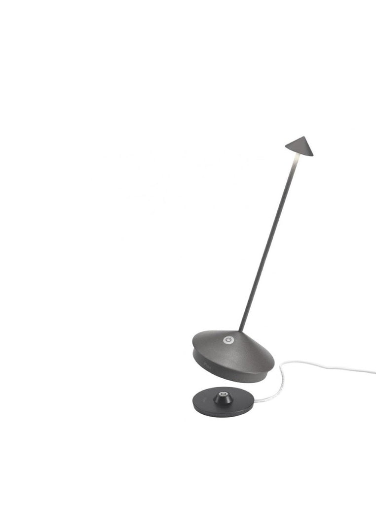The Pina Pro Rechargeable Lamp by Ai Lati for Zafferano features a sleek and small body and wide base to anchor the lamp. Its clean design perfectly suits small settings offering a crisp and bright light to a space. Features a die-cast LED lamp with polycarbonate diffuser, 13+ hours of rechargeable battery life, and portable body makes the Pina Pro an excellent accents to a space. Touch-dimmable. Contact charging base with USB cable included. Suitable for indoor or outdoor use.