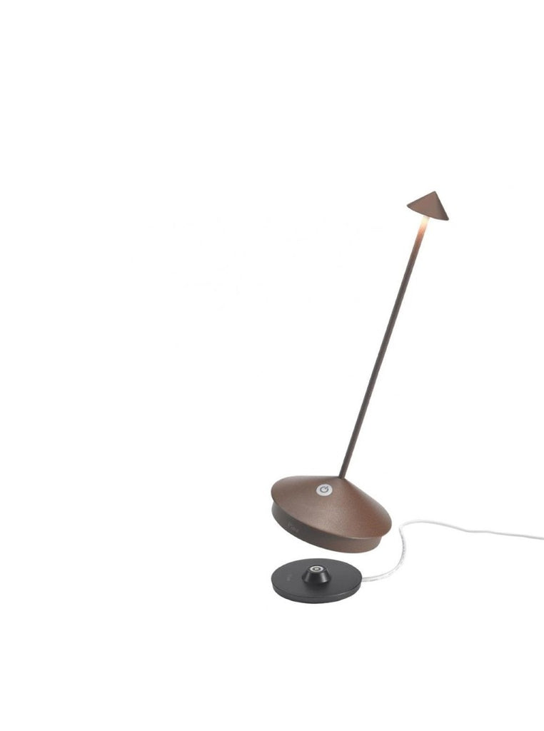 The Pina Pro Rechargeable Lamp by Ai Lati for Zafferano features a sleek and small body and wide base to anchor the lamp. Its clean design perfectly suits small settings offering a crisp and bright light to a space. Features a die-cast LED lamp with polycarbonate diffuser, 13+ hours of rechargeable battery life, and portable body makes the Pina Pro an excellent accents to a space. Touch-dimmable. Contact charging base with USB cable included. Suitable for indoor or outdoor use.