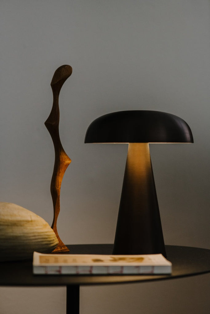 Como SC53, a portable table lamp from Space Copenhagen. Crafted from anodized aluminum, Como’s sturdy base tapers up towards a softy curved, mushroom-shaped shade. This battery-powered lamp can operate for eleven hours at the highest setting, with an extra battery option that allows additional operating. It is easily recharged with a magnetic USB cable or a charging tray.