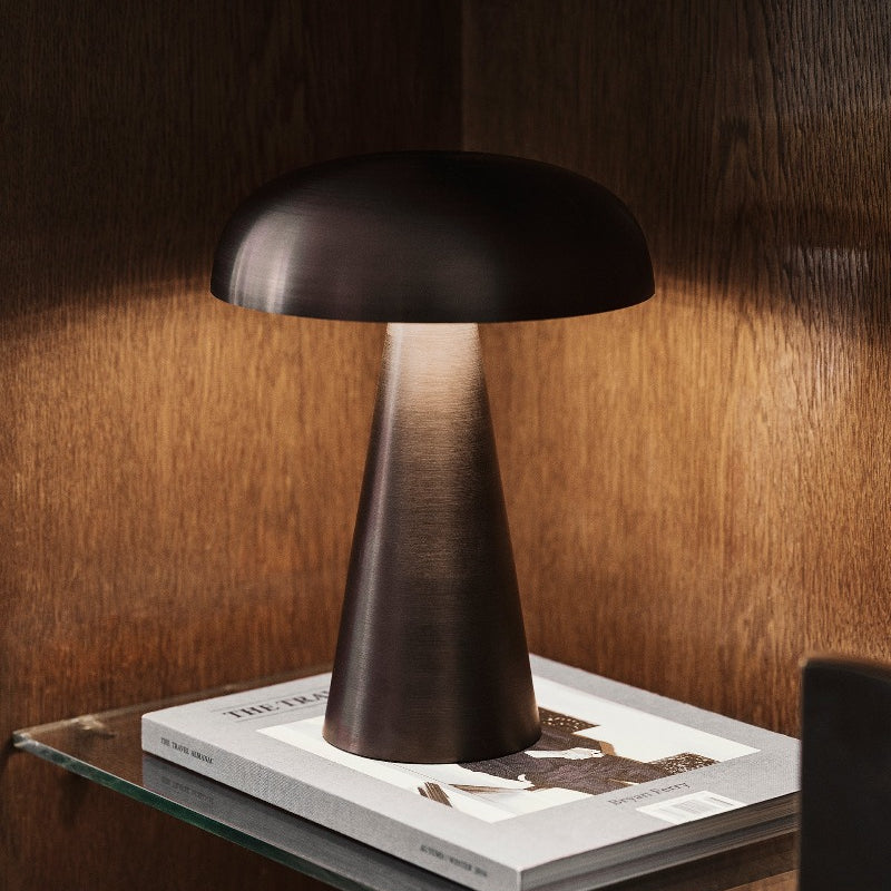 Como SC53, a portable table lamp from Space Copenhagen. Crafted from anodized aluminum, Como’s sturdy base tapers up towards a softy curved, mushroom-shaped shade. This battery-powered lamp can operate for eleven hours at the highest setting, with an extra battery option that allows additional operating. It is easily recharged with a magnetic USB cable or a charging tray.