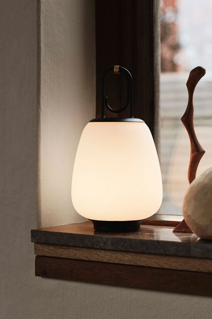 The Lucca Portable Table Lamp by Space Copenhagen for &Tradition. This elegant portable lamp, inspired by the golden glow of the Tuscan city of Lucca, mimics the warmth of the city’s nocturnal light.