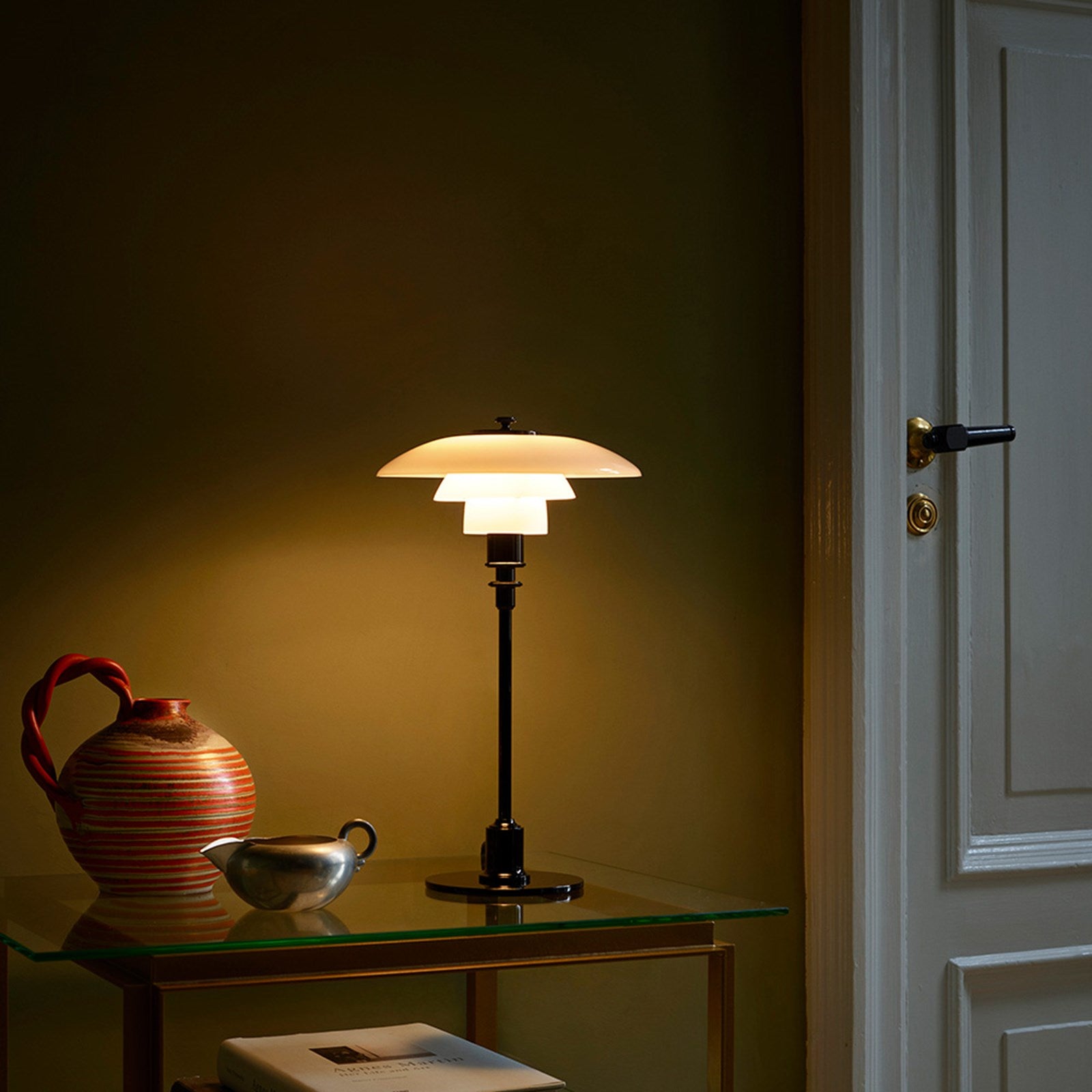 The PH 2/1 Table Light by Paul Henningsen for Louis Poulsen features a triple-layer hand blown glass shade that rests on a beautiful, lightly brushed brass frame, which references the original PH Table Lamp from 1927. Its design evokes timeless elegance with its use of classic materials. Complimenting environments both simple and eclectic, the PH 2/1 boasts a small profile making the lamp endlessly adaptable anywhere within the home, like on a windowsill or small table. 