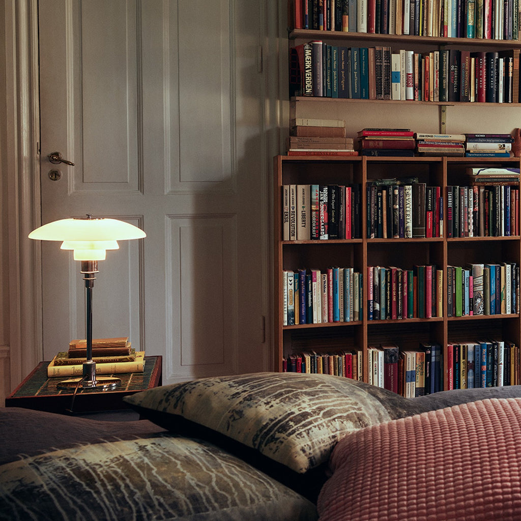 The PH 3/2 Table Light by Paul Henningsen for Louis Poulsen features a reflective three-shade system, which directs the majority of the light downwards. The shades are made of hand-blown opal three-layer glass, which is glossy on top and sandblasted matte on the underside, giving a soft and diffused light distribution.