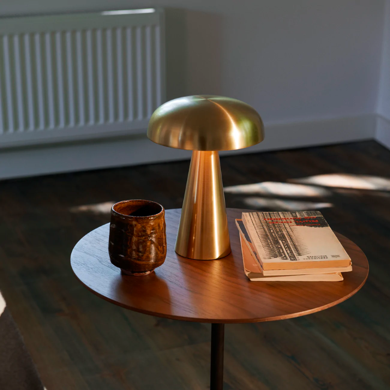 Como SC53, a portable table lamp from Space Copenhagen. Crafted from anodized aluminum, Como’s sturdy base tapers up towards a softy curved, mushroom-shaped shade. This battery-powered lamp can operate for eleven hours at the highest setting, with an extra battery option that allows additional operating. It is easily recharged with a magnetic USB cable or a charging tray.