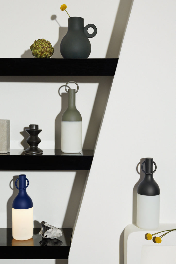 Get ready for the great outdoors with the ELO Rechargeable LED Portable Table Lamp from DesignerBox. Created with an eye toward French design by Bina Baitel, it starts with a handle that flares out into a dome shape, seating weatherproof and dimmable LED lamping inside a cylindrical, translucent shade that blocks excess glare, transforming it into a pleasant glow.