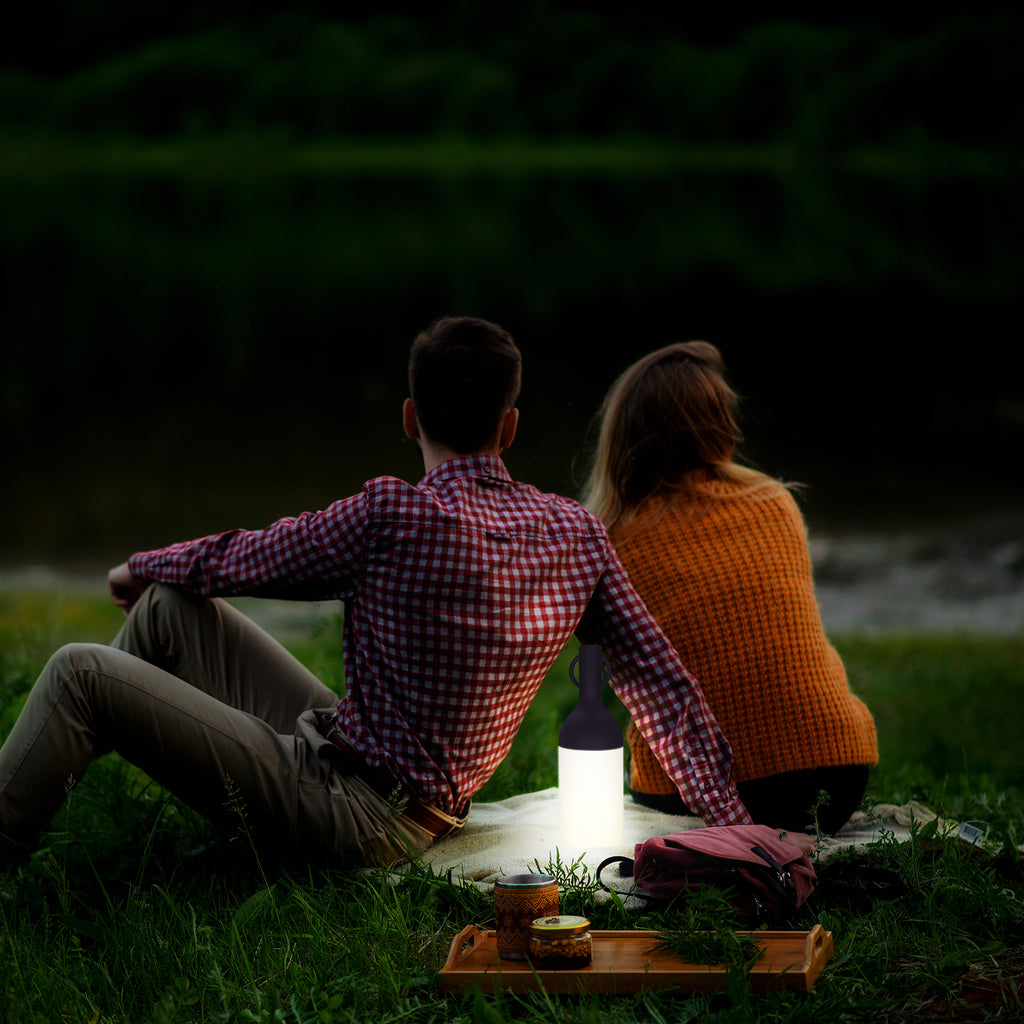 Get ready for the great outdoors with the ELO Rechargeable LED Portable Table Lamp from DesignerBox. Created with an eye toward French design by Bina Baitel, it starts with a handle that flares out into a dome shape, seating weatherproof and dimmable LED lamping inside a cylindrical, translucent shade that blocks excess glare, transforming it into a pleasant glow.