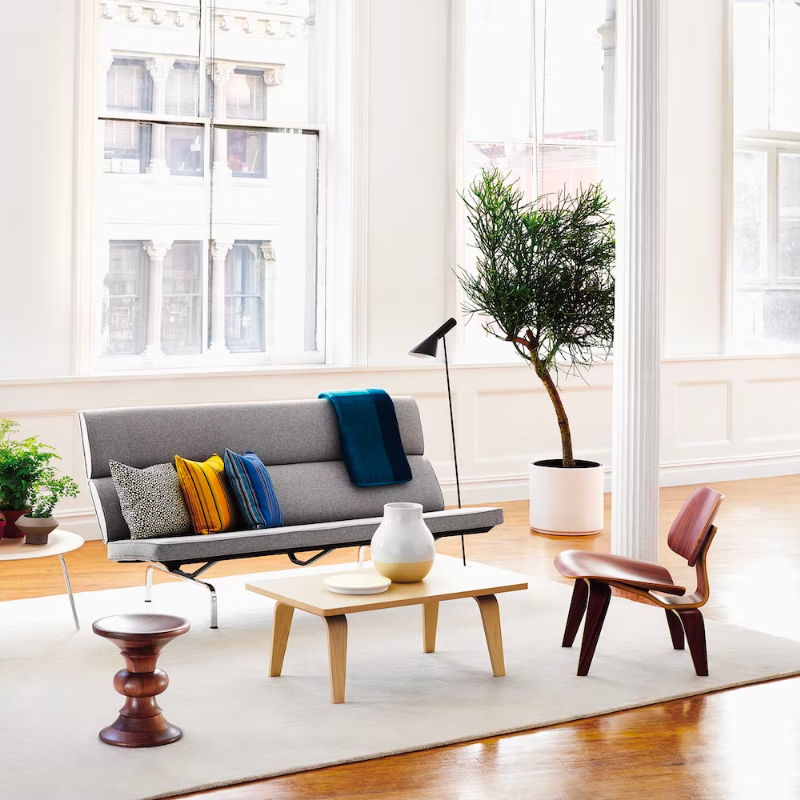 The Eames Molded Plywood Lounge Chair Wood Base (LCW) from Herman Miller in a living room.