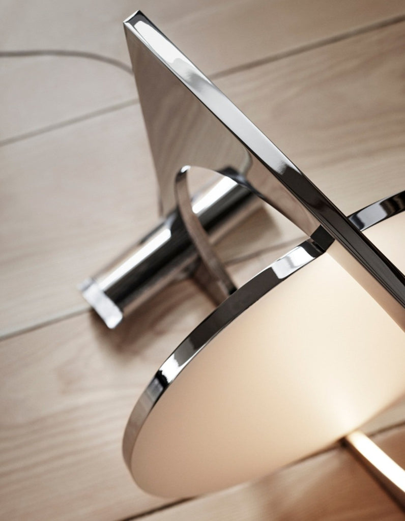 The sculptural Moonsetter floor lamp by Louis Poulsen in chrome-plated aluminum has a rotating disc that allows customization of the reflection of the glare-free light emitted by the LED light source elegantly submerged in the frame. Design by Anne Boysen.