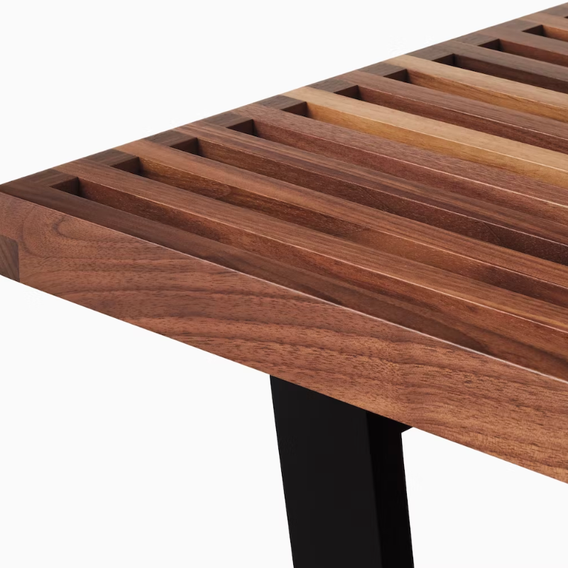 The Nelson Platform Bench from Herman Miller in walnut with the wood base in a detailed photograph.