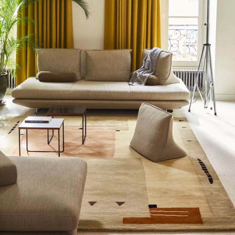 The Silva Area Rug from Toulemonde Boachart enlivens its surroundings with a signature, retro appeal. A rectangular piece created by Jean-Jacques Beaumé and made from New Zealand wool, it utilizes his experience with 1930s design, creating an updated, abstract presence that plays with stacked, interspersed rectangular patterns. These contrasting rectangles are further embellished by small triangles and wavy, segmented lines, creating a playful, enduring presence.
