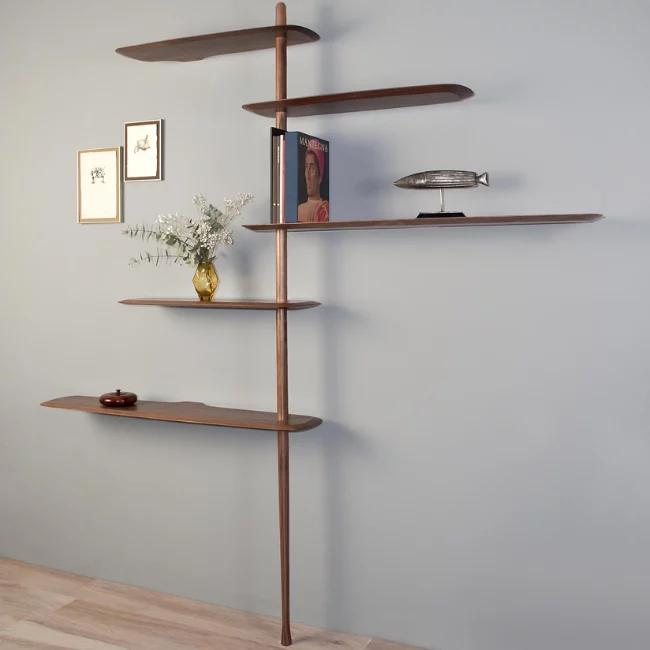 Rise in style with the smooth surfaces and open expressiveness of the Unica Floor Shelving System from Nomon. A smooth design from the mind of Andres Martinez, it ascends along a single solid walnut rod that telescopes out from a narrower point, seating alternating fixed and “floating” shelves with a smooth walnut veneer along its length. 