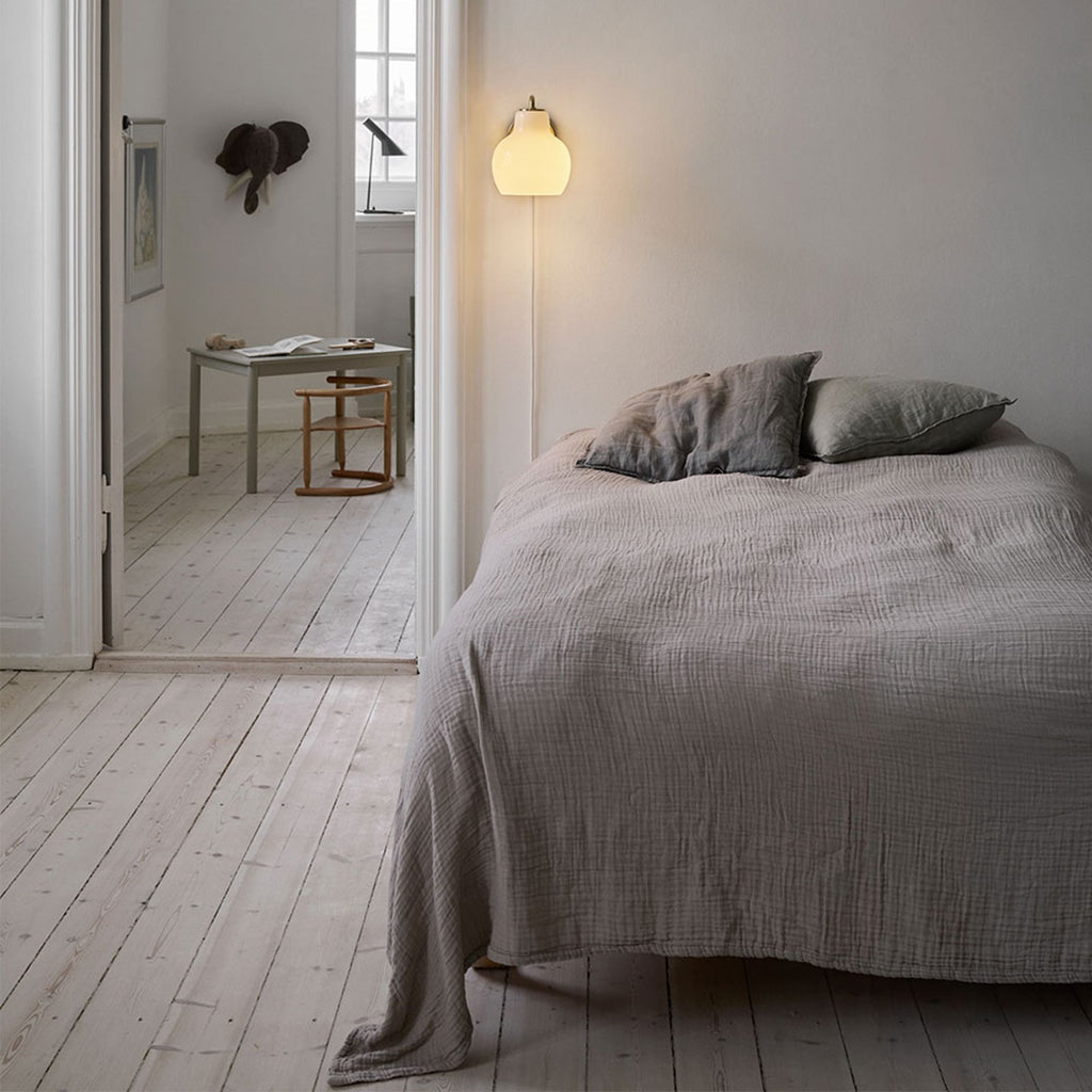 The VL Ring Crown wall sconce by Louis Poulsen has a characteristically organic form that emits light directed primarily downwards, while the opal glass provides a comfortable and uniform illumination of the area around the fixture.