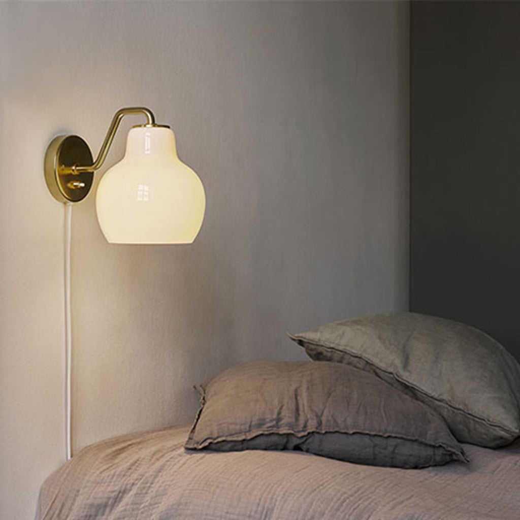 The VL Ring Crown wall sconce by Louis Poulsen has a characteristically organic form that emits light directed primarily downwards, while the opal glass provides a comfortable and uniform illumination of the area around the fixture.