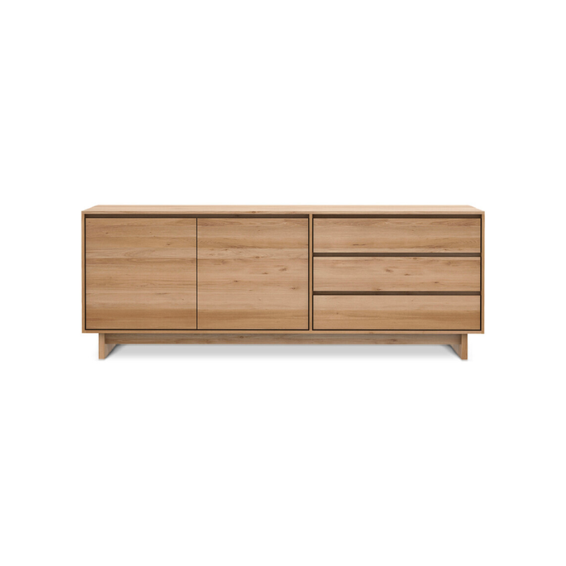 The Wave Sideboard by Ethnicraft features contoured cabinet doors and a distinguished shape to the feet. Made of solid wood, this cabinet’s doors and drawers have no handles and feature a soft closing mechanism.